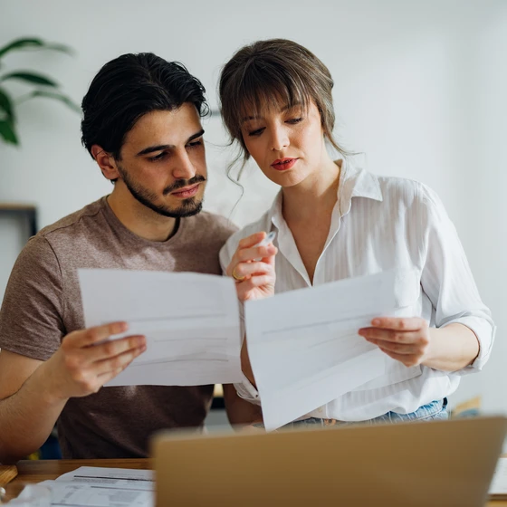 Deux personnes regardent des documents pour comparer.
