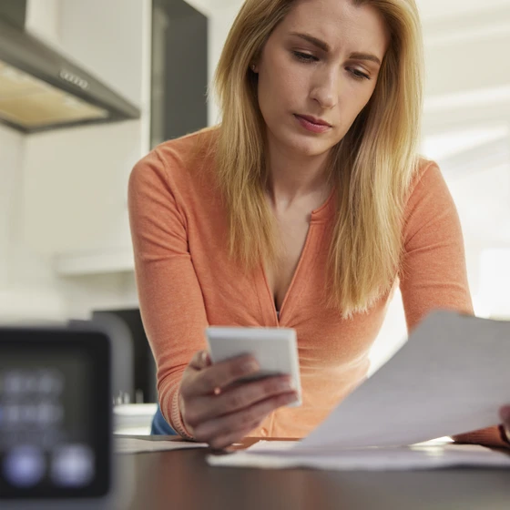 Une jeune femme décrypte sa facture d'électricité suite à l'augmentation des prix.