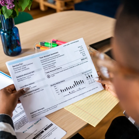 Un homme regarde sa facture pour identifier certain élément.