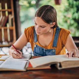 Une étudiante étudie sur des livres.