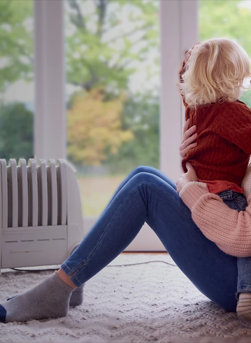 Femme et enfant dans un salon avec un radiateur