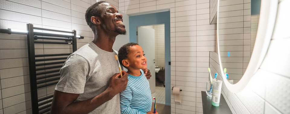 père et son fils qui se brossent les dents dans une salle de bain