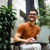 Homme sur ordinateur avec en fond des plantes